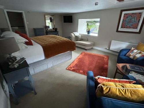 um quarto com uma cama e uma sala de estar com um sofá em The Maltsters Arms em Totnes