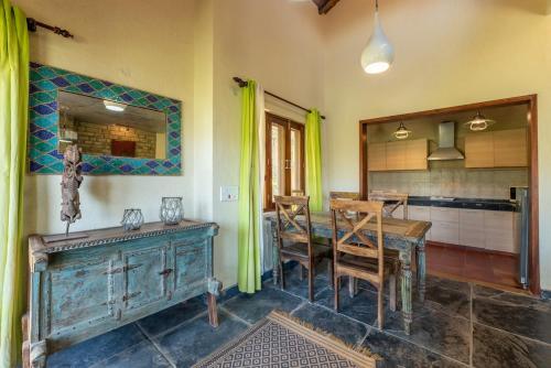 een keuken met een houten tafel en een eetkamer bij Wild Thyme - Levitate at Ramgarh by Roamhome in Rāmgarh