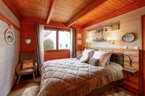 a bedroom with a bed in a wooden room at L'écrin de bois -sauna - spa in Mur-de-Bretagne