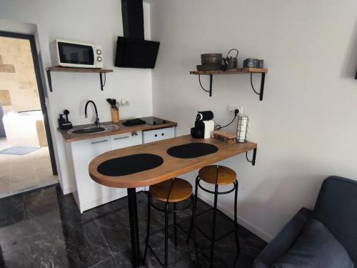 eine kleine Küche mit Tisch und Spüle in der Unterkunft Apocalypse Love Room in Vianne