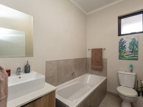 Woodland Haven في ميدراند: حمام مع حوض استحمام ومرحاض ومغسلة
