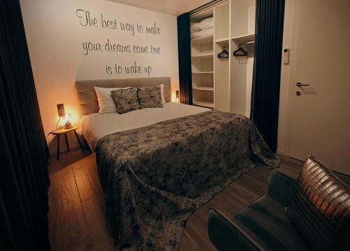 ein Schlafzimmer mit einem Bett mit einem Zitat an der Wand in der Unterkunft De Konik in Uikhoven