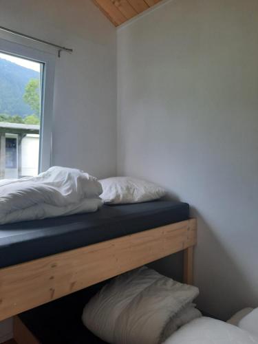 two beds in a room with a window at Parc Sonnleiten - Chalet 4 persoons in Gnesau