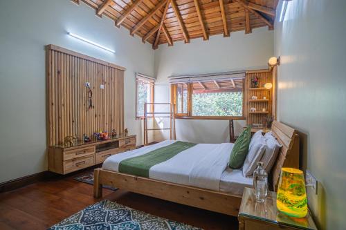 a bedroom with a bed and a table and a window at ELIVAAS Tapovan Estate 2-BHK With Kids Attic, Garden, Gazebo and Scenic Views in Bhowāli