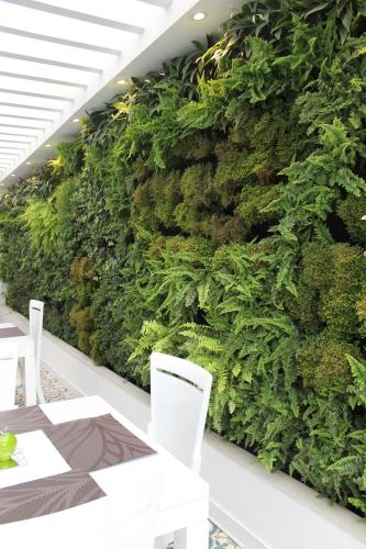 a green wall with white chairs and a table at Casa Hotel Boyaca Real in Bogotá