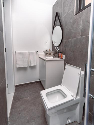 a bathroom with a white toilet and a mirror at Golf View Apartments- AP1 in Maputo