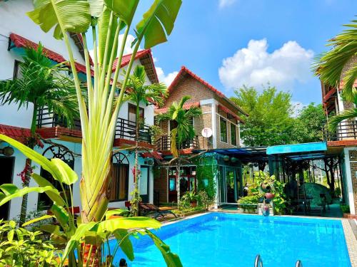 a resort with a swimming pool in front of a building at Tam Coc Mandala Villa & Homestay in Ninh Binh
