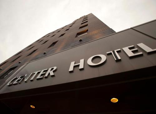 a building with a sign for a higher hotel at Center Hotel Toyota in Toyota