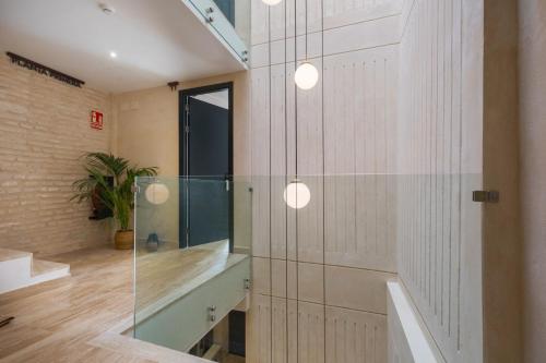 塞维利亚Luxurious Duplex 1Bd 1Bth over Casa Pilatos的一间设有玻璃墙和两个灯的房间