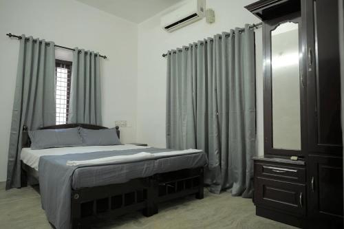 a bedroom with a bed and a dresser and a mirror at Tree Fort Homestay in Cochin