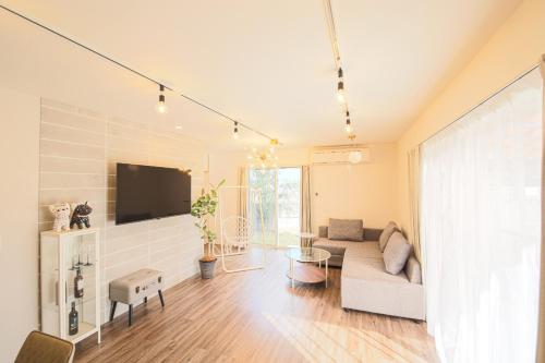 Una sala de estar con un sofá y un televisor en KOTOVilla JR琴平駅近く丸々貸切一棟室内アスレチック, en Kotohira