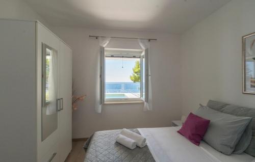ein weißes Schlafzimmer mit einem Bett und einem Fenster in der Unterkunft Villa Toma by Villas Guide in Gornji Dingač