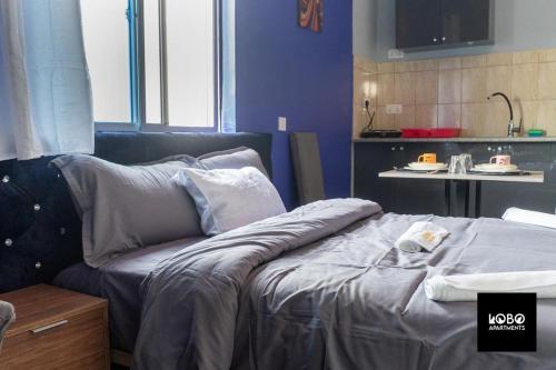 een woonkamer met een bed en een keuken bij Studio apartment complex in Serekunda