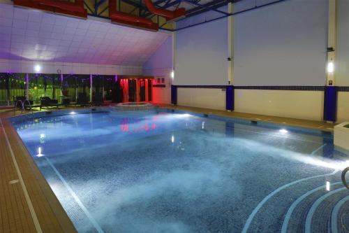 a large swimming pool with blue water in a building at Buchanan Arms Hotel & Leisure, Sure Hotel Collection in Drymen
