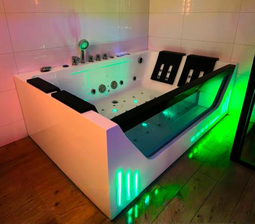 a bath tub with green lights in a bathroom at Willa Pienińska 123 in Maniowy