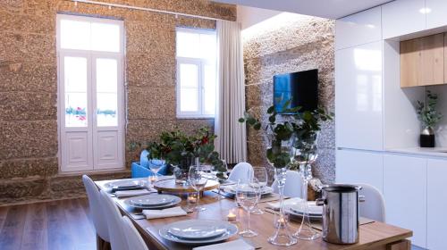 a dining room with a table with white chairs at D Maria Apartments in Vila Nova de Famalicão