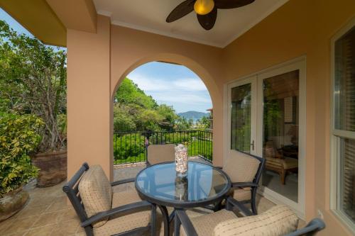 a patio with a glass table and chairs on a balcony at Bella Vista 8B 3 bedr 3 1 and half bath in Jacó