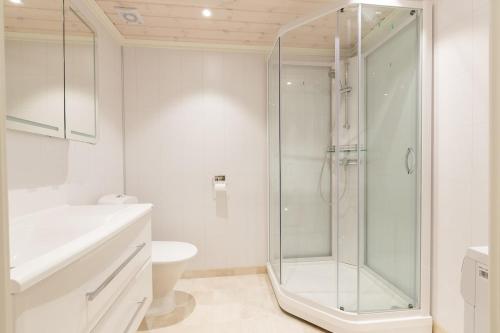 ein weißes Badezimmer mit Dusche und Toilette in der Unterkunft Stranda Fjellgrend 3 bedrooms and loft - 80C in Stranda