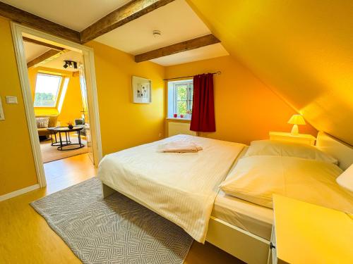 Lancken-GranitzにあるVogelhaus Gobbinの黄色の壁のベッドルーム1室、ベッド1台が備わります。