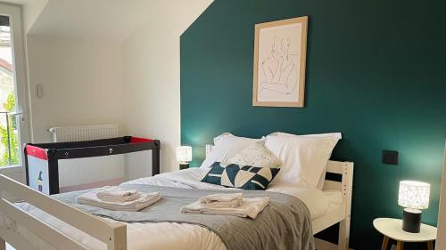 ein Schlafzimmer mit einem Bett mit einer blauen Wand in der Unterkunft Gîte L'Écrin - Maison de charme 8Pers - By Primo in Buxy