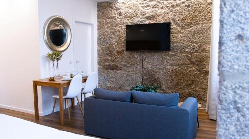 a living room with a blue couch and a table at D Maria Apartments in Vila Nova de Famalicão