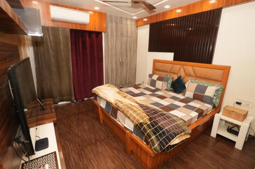 加济阿巴德Adriadna Homes City Comfort Stay Simple, Stylish Comfortable的一间卧室，里面有一张床和一台平板电视