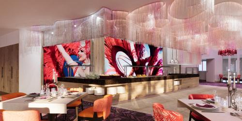 un comedor con mesas y sillas y una gran pintura en Royal Palace Hotel & Spa, en Kirrwiller