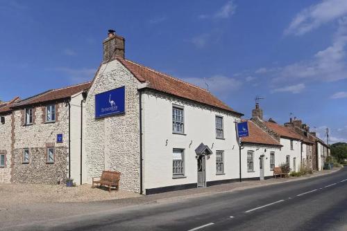 a white building on the side of a street at The Ostrich Inn, South Creake, Norfolk in South Creake