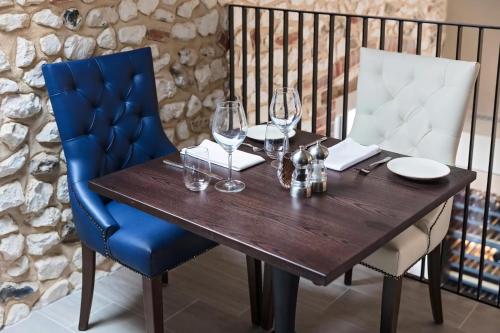 a wooden table with two chairs and wine glasses at The Ostrich Inn, South Creake, Norfolk in South Creake