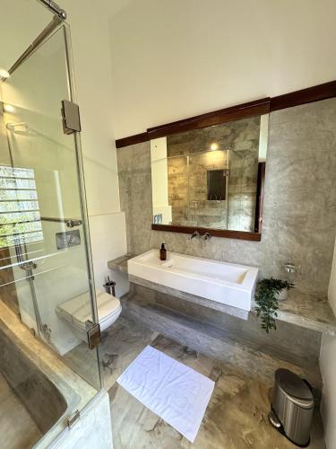 a bathroom with a sink and a shower and a mirror at Luxe Hideaway in Colombo