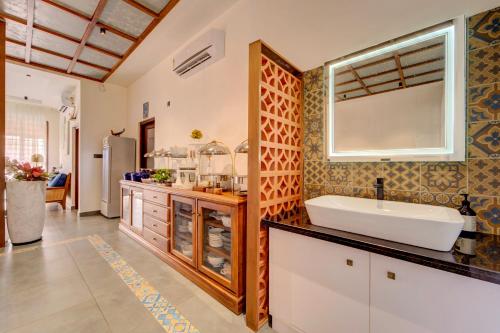 Breeze and Grains Resort 3-BHK Villa with Verandah & Outdoor Patio في Champakulam: حمام مع حوض ومرآة