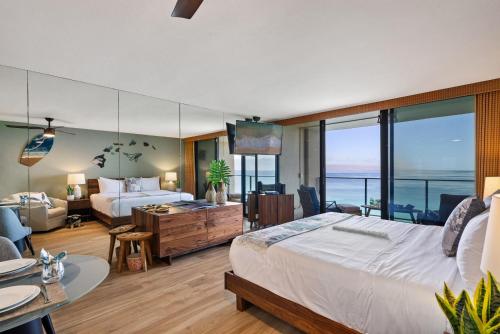 a bedroom with a large bed and a living room at Mahana 1202 · MA 1202 OceanFront Penthouse Studio in Kaanapali in Kahana