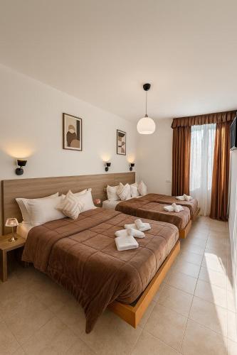 two beds in a bedroom with towels on them at Hotel Aurelia Milano Centrale in Milan