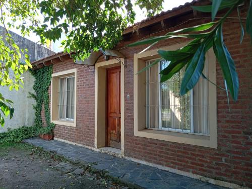ein Backsteinhaus mit brauner Tür und Fenstern in der Unterkunft Casa Las Marías in General Belgrano