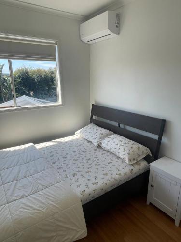 a bedroom with a white bed with a window at Perfect peaceful stay in Melton