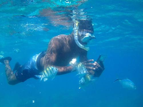 a man is in the water in the water at Sol & Arena Bayahibe Apartment in Bayahibe