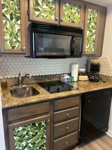 a kitchen with a sink and a microwave at Ocean & Pool View - Hot Tubs - 2 Pools - Gym - Tennis ct - on seawall - Shoreline Stays 08 in Galveston