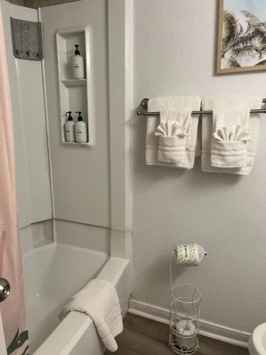 a bathroom with a shower and a bath tub with towels at Ocean & Pool View - Hot Tubs - 2 Pools - Gym - Tennis ct - on seawall - Shoreline Stays 08 in Galveston