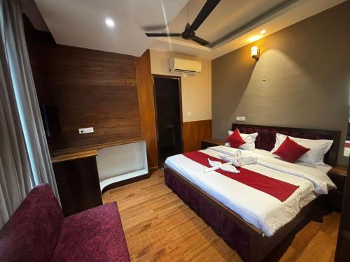 a hotel room with a large bed with red pillows at Hotel Maria in Dera Bassi