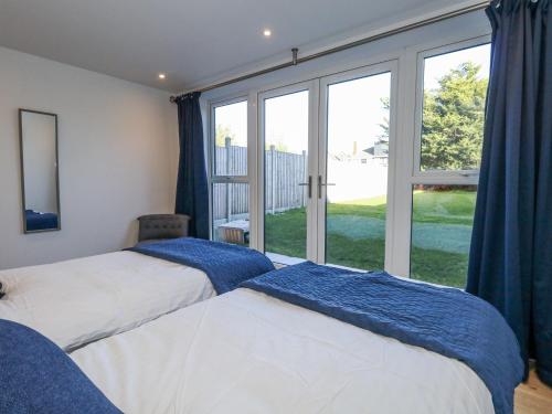 two beds in a bedroom with a large window at Sea Fern House - 36B in Poole