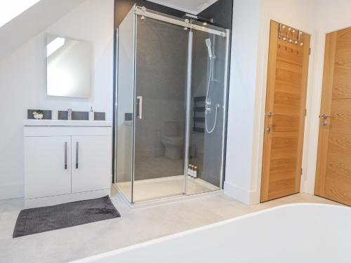a glass shower in a bathroom with a sink at Sea Fern House - 36B in Poole
