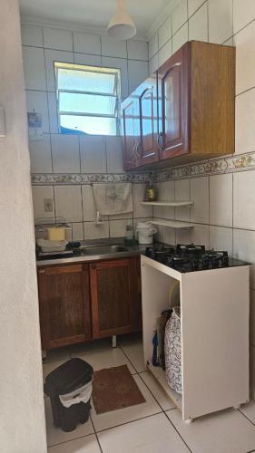 eine Küche mit Spüle und Herd Oberer Backofen in der Unterkunft Apartamento de 1 quarto próximo a praia - Com Estacionamento Rotativo in Tramandaí
