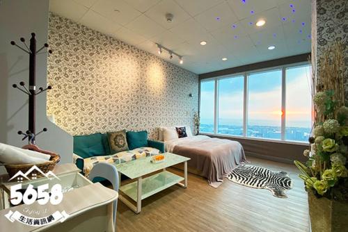 ein Schlafzimmer mit einem Bett, einer Couch und einem Tisch in der Unterkunft 85高雄港商旅 in Ta-lin-wei