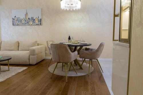 una sala de estar con una mesa, sillas y un sofá en Premium Planet Deluxe, en Niš