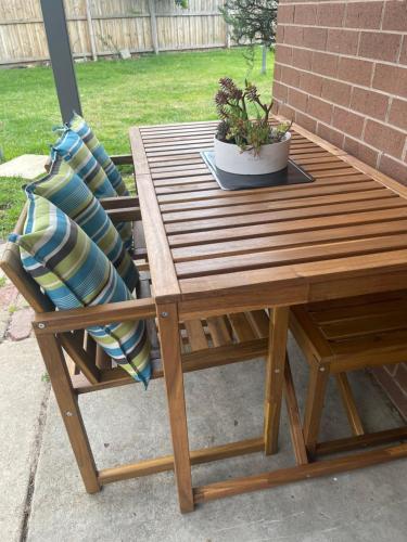 a wooden table and a chair with a potted plant at Daisy House - Whittington - 10 minutes to central Geelong in Whittington