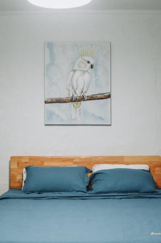 a painting of a white bird sitting on a branch at The Coastal Charm in Grand-Baie