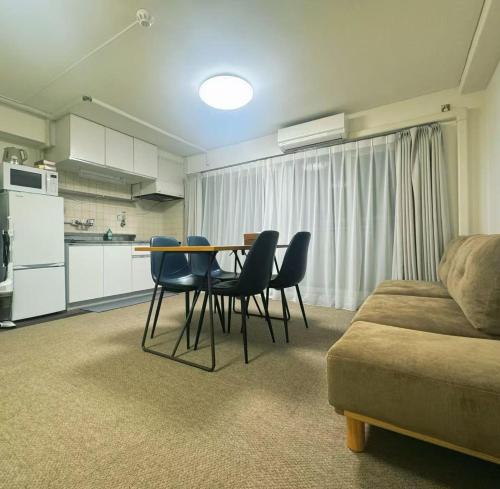 a living room with a table and chairs and a couch at LoveTokyo Easy Access Nezu Sunset House 根津駅徒歩1分 エレベーター 上野 谷中銀座 根津神社 東京大学 新宿 渋谷 銀座 築地 原宿近い in Tokyo