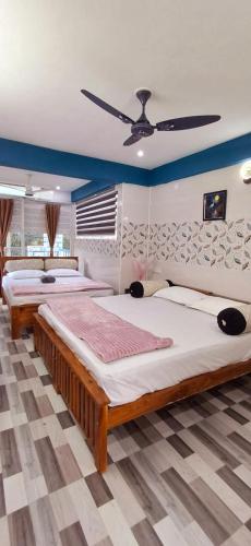 a bedroom with two beds and a ceiling fan at Cloud Mist Inn YERCAUD in Yercaud