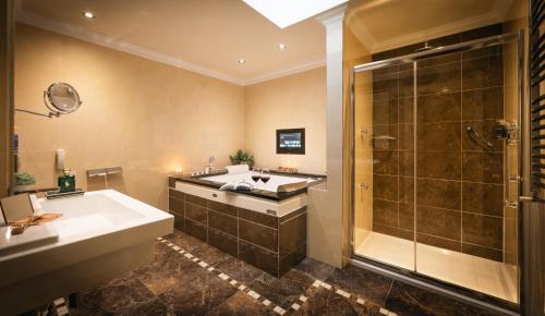 un bagno con vasca, doccia e lavandino di The Fairview Boutique Hotel a Killarney