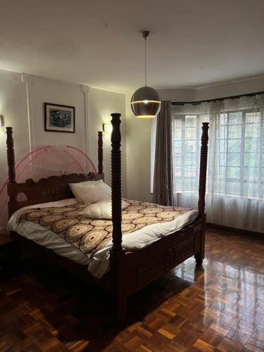 Cozy Two-Bed Retreat في نيروبي: غرفة نوم بسرير مع اطار خشبي